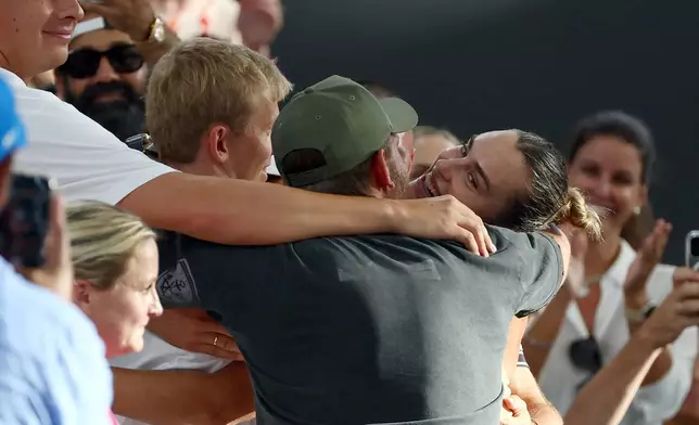 Aryna Sabalenka of Belarus, right, hugs her support team after winning the women's final match against Marta Kostyuk of Ukraine 6-4, 6-3, at the Brisbane International tennis tournament in Brisbane, Australia, Sunday, Jan. 11, 2026. (AP Photo/Tertius Pickard)