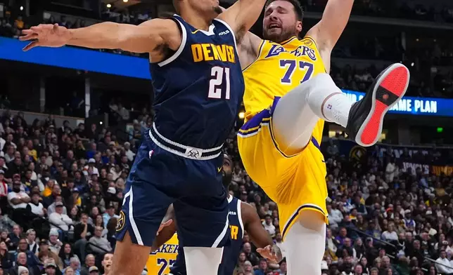 Denver Nuggets forward Spencer Jones (21) fouls Los Angeles Lakers forward Luka Dončić (77) during the first half of an NBA basketball game Tuesday, Jan. 20, 2026, in Denver. (AP Photo/Jack Dempsey)
