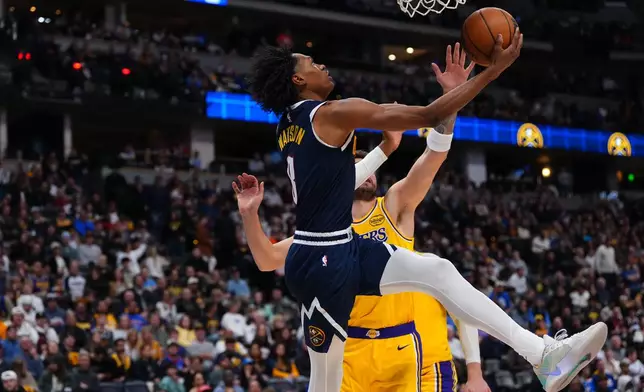 Denver Nuggets guard Peyton Watson (8) goes up for a shot against Los Angeles Lakers forward/guard Luka Dončić (77). during the second half of an NBA basketball game Tuesday, Jan. 20, 2026, in Denver. (AP Photo/Jack Dempsey)