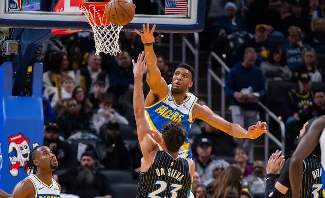 Indiana Pacers center Tony Bradley reaches out to block a shot by Orlando Magic forward Tristan da Silva (23) during the first half of an NBA basketball game in Indianapolis, Wednesday, Dec. 31, 2025. (AP Photo/Doug McSchooler)