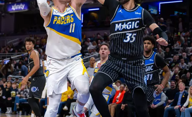 Indiana Pacers center James Wiseman (11) shoots while being defended by Orlando Magic center Goga Bitadze (35) during the first half of an NBA basketball game in Indianapolis, Wednesday, Dec. 31, 2025. (AP Photo/Doug McSchooler)