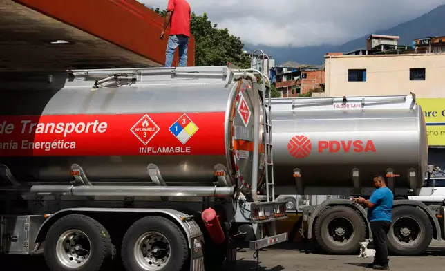 Fuel tanker trucks unload fuel at a gas station in Caracas, Venezuela, Wednesday, Jan. 7, 2026. (AP Photo/Cristian Hernandez)