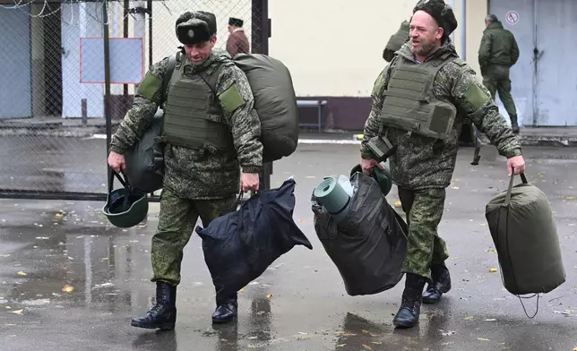 FILE - Recruits carry their gear at a military recruitment center in Rostov-on-Don, Russia, Oct. 31, 2022. (AP Photo, File)