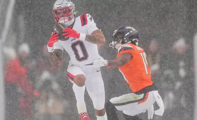 New England Patriots cornerback Christian Gonzalez intercepts a pass intended for Denver Broncos wide receiver Marvin Mims Jr. (19) during the second half of the AFC Championship NFL football game, Sunday, Jan. 25, 2026, in Denver. (AP Photo/David Zalubowski)