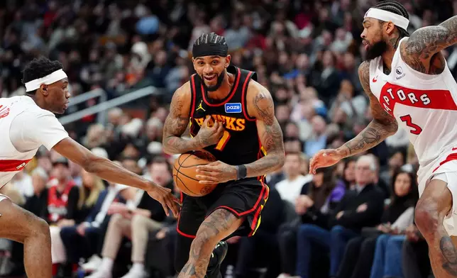 Atlanta Hawks guard Nickeil Alexander-Walker, center, has the ball stripped by Toronto Raptors guard Ja'kobe Walter, left, as Raptors' Brandon Ingram (3) looks on during second-half NBA basketball game action in Toronto, Monday, Jan. 5, 2026. (Frank Gunn/The Canadian Press via AP)
