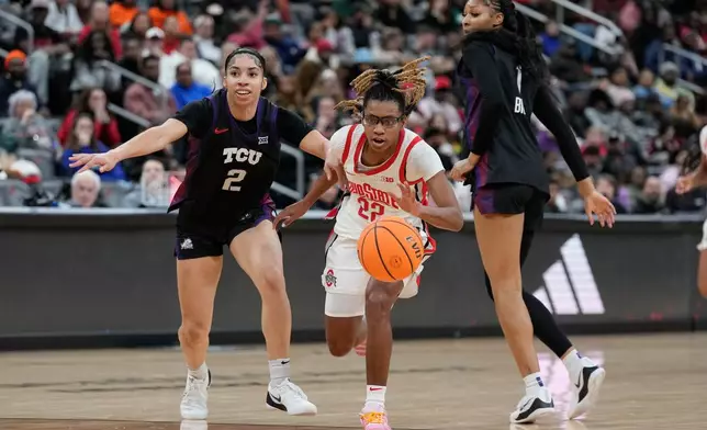 Ohio State's Jaloni Cambridge, center, drives between TCU's Veronica Sheffey, left, and Taylor Bigby during the first half of an NCAA women's college basketball game in Newark, N.J., Monday, Jan. 19, 2026. (AP Photo/Seth Wenig)