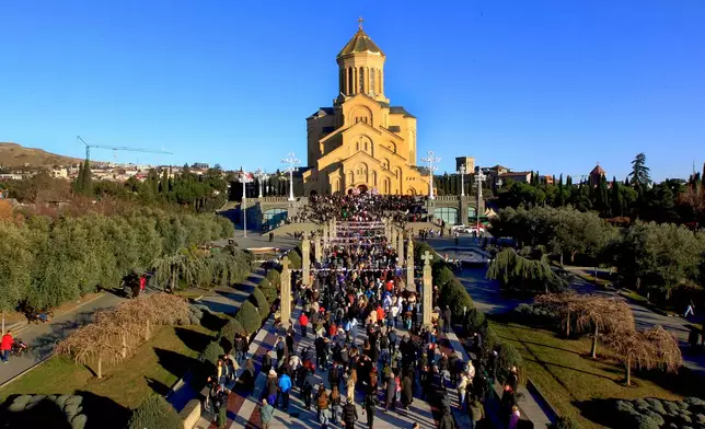 Georgians with national flags take part in a religious procession to the Holy Trinity Cathedral to mark Orthodox Christmas in Tbilisi, Georgia, Wednesday, Jan. 7, 2026. (AP Photo/Shakh Aivazov)