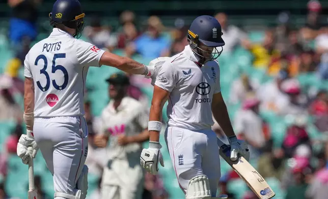 England's Matthew Potts, left, gestures to teammate Jacob Bethell after he was dismissed during play on the last day of the fifth and final Ashes cricket test between England and Australia in Sydney, Thursday, Jan. 8, 2026. (AP Photo/Mark Baker)