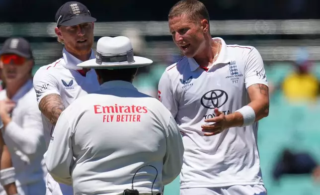 England's Brydon Carse, right, and teammate Ben Stokes talk to umpire Ahsan Raza during play on the last day of the fifth and final Ashes cricket test between England and Australia in Sydney, Thursday, Jan. 8, 2026. (AP Photo/Mark Baker)