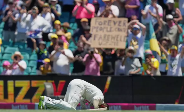 Australia Usman Khawaja kisses the turf as he leaves the field during play on the last day of the fifth and final Ashes cricket test between England and Australia in Sydney, Thursday, Jan. 8, 2026. (AP Photo/Mark Baker)