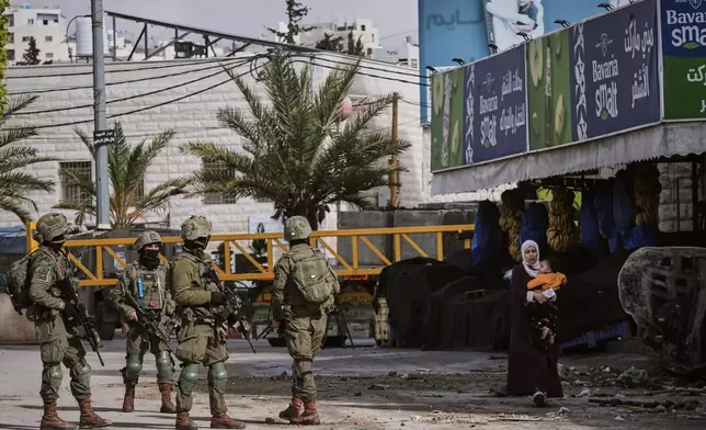 Israeli soldiers take up positions during an army raid in the West Bank city of Hebron Monday, Jan. 19, 2026. (AP Photo/Mahmoud Illean)
