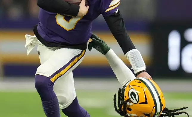 Minnesota Vikings quarterback J.J. McCarthy (9) runs from Green Bay Packers linebacker Ty'ron Hopper (59) during the first half of an NFL football game, Sunday, Jan. 4, 2026, in Minneapolis. (AP Photo/Ross D. Franklin)