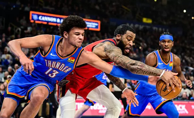 New Orleans Pelicans guard/forward Saddiq Bey (41) goes for the free ball against Oklahoma City Thunder forward Ousmane Dieng (13) during the first half of an NBA basketball game Tuesday, Jan. 27, 2026, in Oklahoma City. (AP Photo/Gerald Leong)