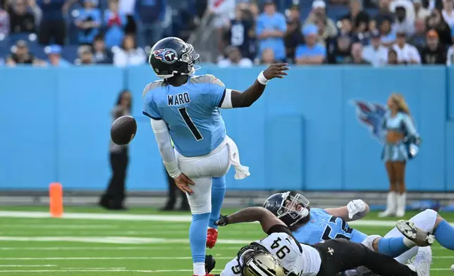 Tennessee Titans quarterback Cam Ward (1) is tripped up by New Orleans Saints defensive end Cameron Jordan (94) on the last play of the game, in the second half of an NFL football game, Sunday, Dec. 28, 2025, in Nashville, Tenn. (AP Photo/John Amis)