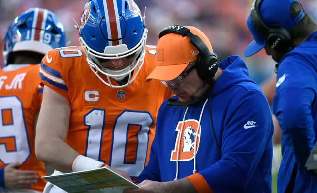 Denver Broncos head coach Sean Payton talks with quarterback Bo Nix (10) during the first half of an NFL football game against the Los Angeles Chargers in Sunday, Jan. 4, 2026, in Denver. (AP Photo/Eric Lutzens)