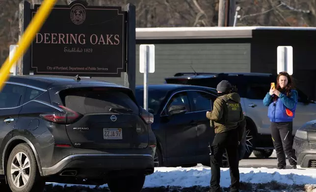 A woman films a Homeland Security Investigations agent at a parking lot at Deering Oaks Park, Friday, Jan. 23, 2026, in Portland, Maine.(AP Photo/Robert F. Bukaty)