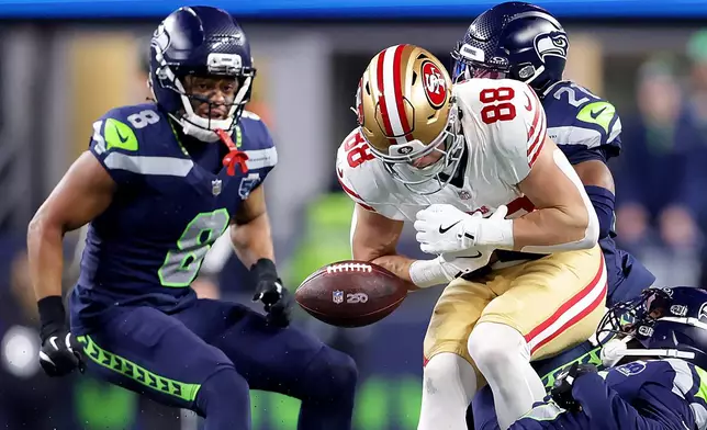 San Francisco 49ers Jake Tonges (88) fumbles the ball during the first half of an NFL football divisional playoff game against the Seattle Seahawks, Saturday, Jan. 17, 2026, in Seattle. (Scott Strazzante/San Francisco Chronicle via AP)