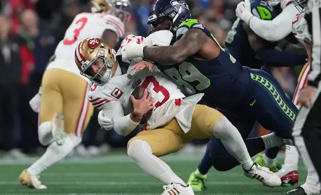 Seattle Seahawks defensive tackle Leonard Williams (99) sacks San Francisco 49ers quarterback Brock Purdy (13) during the second half of an NFL football divisional playoff game Saturday, Jan. 17, 2026, in Seattle. (AP Photo/Lindsey Wasson)