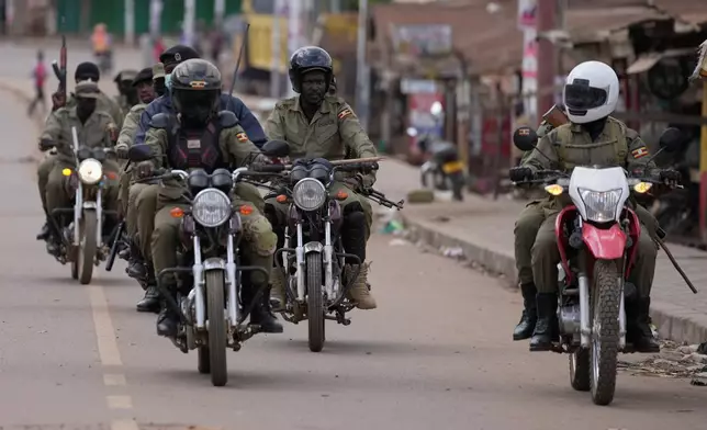 Uganda's security forces patrol a street during protests following the announcement of the preliminary results in Kampala, Uganda, Friday, Jan. 16, 2026. (AP Photo/Brian Inganga)