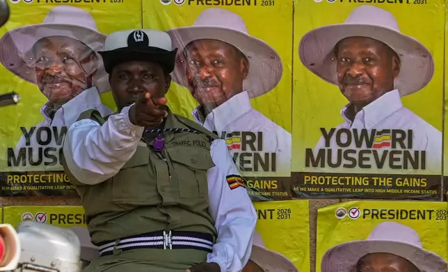 A traffic police officer sits in front of campaign posters of President Yoweri Museveni, the National Resistance Movement (NRM) presidential candidate, during the general election, in Kampala, Uganda, Thursday, Jan. 15, 2026. (AP Photo/Brian Inganga)