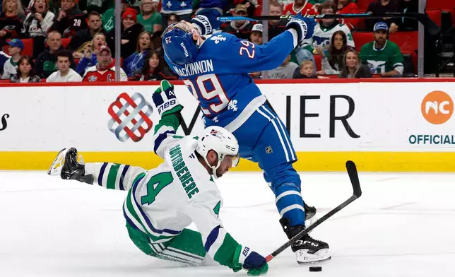 Carolina Hurricanes' Shayne Gostisbehere (4) takes down Colorado Avalanche's Nathan MacKinnon (29) resulting in an awarded goal during the third period of an NHL hockey game in Raleigh, N.C., Saturday, Jan. 3, 2026. (AP Photo/Karl DeBlaker)