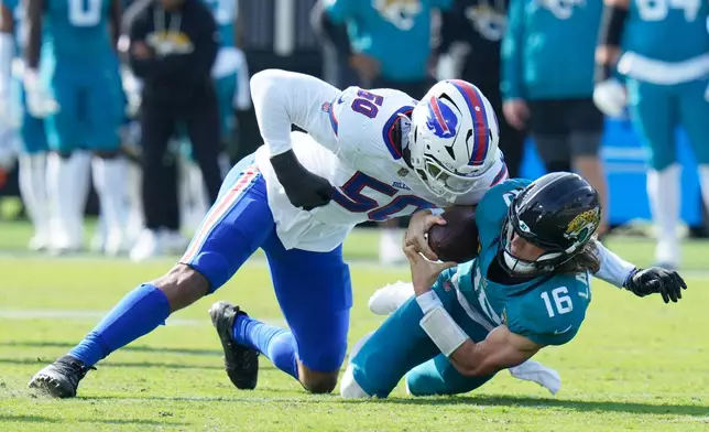 Jacksonville Jaguars quarterback Trevor Lawrence (16) is sacked by Buffalo Bills defensive end Greg Rousseau (50) during the first half of an NFL wild-card playoff football game Sunday, Jan. 11, 2026, in Jacksonville, Fla. (AP Photo/Chris O'Meara)