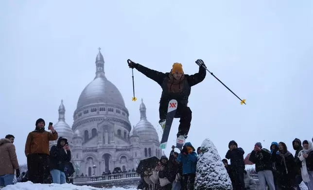 FILE - A man skies down the hill by the Sacre-Coeur basilica during a snowfall in the Montmartre district, Monday, Jan. 5, 2026 in Paris. (AP Photo/Aurelien Morissard, File)