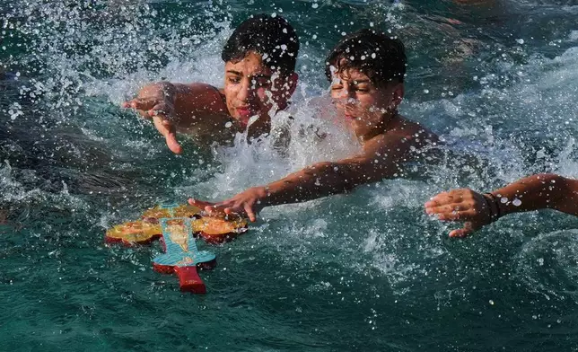 FILE - Youth pilgrims try to catch the cross thrown by an Orthodox priest into the water during an Epiphany ceremony to bless the sea in the southeastern village of Xylophagou, Cyprus, Tuesday, Jan. 6, 2026. (AP Photo/Petros Karadjias, File)