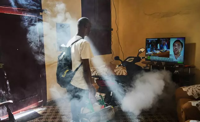 FILE - A mosquito control worker fumigates a home where a television plays a government television news report concerning the U.S. forces' capture of Venezuelan President Nicolas Maduro and his wife, in Old Havana, Cuba, Tuesday, Jan. 6, 2026. (AP Photo/Ramon Espinosa, File)