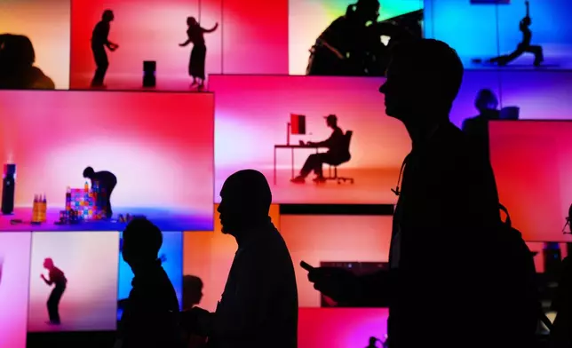 FILE - People pass an LG Electronics display during the CES tech show Tuesday, Jan. 6, 2026, in Las Vegas. (AP Photo/Abbie Parr, File)
