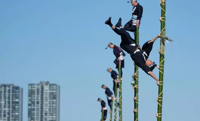 FILE - Members of a traditional firefighting preservation group perform ladder stunts during the annual New Year's Fire Brigade Review Tuesday, Jan. 6, 2026, in Tokyo. (AP Photo/Eugene Hoshiko, File)
