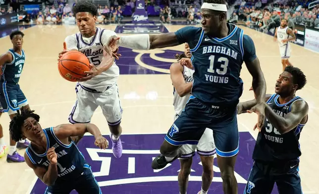 FILE - Kansas State forward Taj Manning, center left, beats BYU forward Keba Keita (13, File) to a rebound during the second half of an NCAA college basketball game Saturday, Jan. 3, 2026, in Manhattan, Kan. (AP Photo/Charlie Riedel, File)