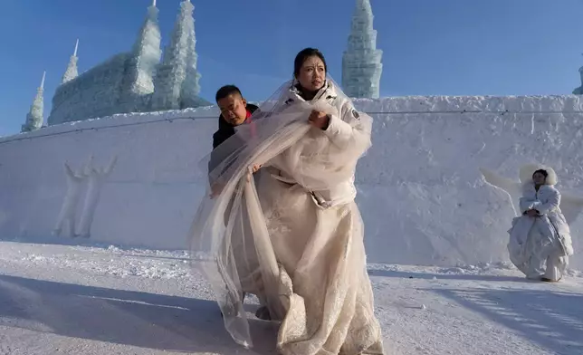 FILE - A couple prepares to take part in a mass wedding in sub zero temperatures during the annual Ice and Snow Festival held in Harbin in northeastern China's Heilongjiang province, Tuesday, Jan. 6, 2026. (AP Photo/Ng Han Guan, File)