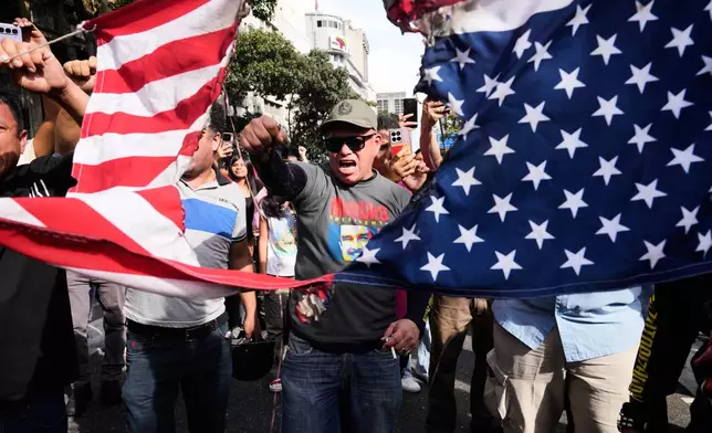 FILE - Government supporters rip an American flag in half during a protest in Caracas, Venezuela, Jan. 3, 2026, after U.S. President Donald Trump announced that U.S. forces had captured President Nicolás Maduro and first lady Cilia Flores. (AP Photo/Ariana Cubillos, File)