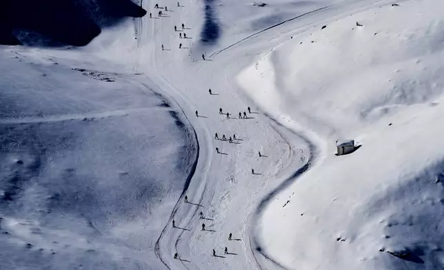 FILE - Skiers cast long shadows as they glide down a slope at the Mzaar-Kfardebian ski resort northeast of Beirut, Lebanon, Saturday, Jan. 3, 2026. (AP Photo/Hassan Ammar, File)