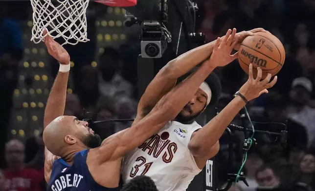 Minnesota Timberwolves center Rudy Gobert, left, fouls Cleveland Cavaliers center Jarrett Allen, right, in the first half of an NBA basketball game Sunday, Jan. 4, 2026, in Cleveland. (AP Photo/Sue Ogrocki)