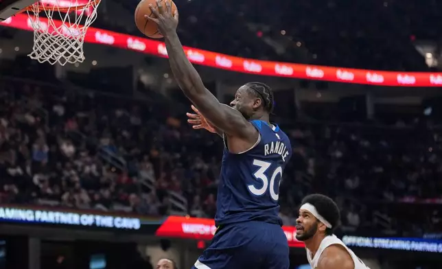 Minnesota Timberwolves forward Julius Randle (30) goes to the basket in front of Cleveland Cavaliers center Jarrett Allen, right, in the first half of an NBA basketball game Sunday, Jan. 4, 2026, in Cleveland. (AP Photo/Sue Ogrocki)