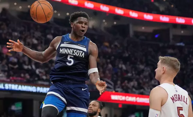 Minnesota Timberwolves guard Anthony Edwards (5) dunks in front of Cleveland Cavaliers guard Sam Merrill, right, in the first half of an NBA basketball game Sunday, Jan. 4, 2026, in Cleveland. (AP Photo/Sue Ogrocki)