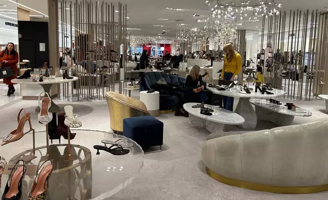 Shoppers look at merchandise at Saks Fifth Avenue on Friday, Jan. 16, 2026 in New York. (AP Photo/Anne D'Innocenzio)