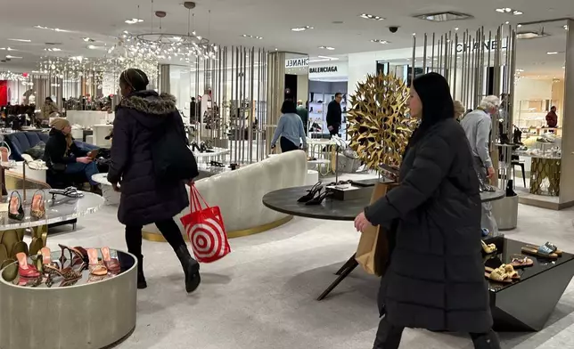 Shoppers walk through Saks Fifth Avenue on Friday, Jan. 16, 2026 in New York. (AP Photo/Anne D'Innocenzio)