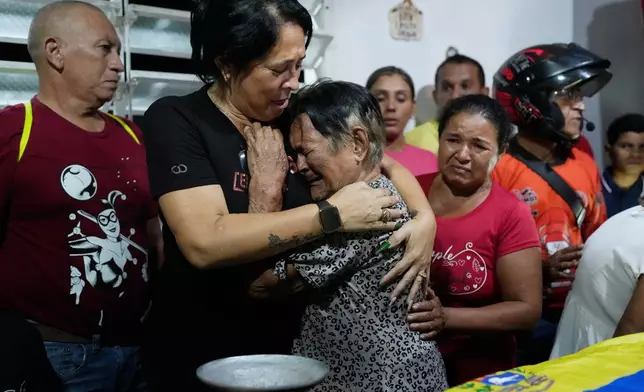Emelyn Torres and Maria Cristina Fernandez, the sister and grandmother of Edilson Torres, a Venezuelan police officer who died in prison after being detained on accusations of treason, embrace during his wake at his home in Guanare, Venezuela, Monday, Jan. 12, 2026. (AP Photo/Ariana Cubillos)