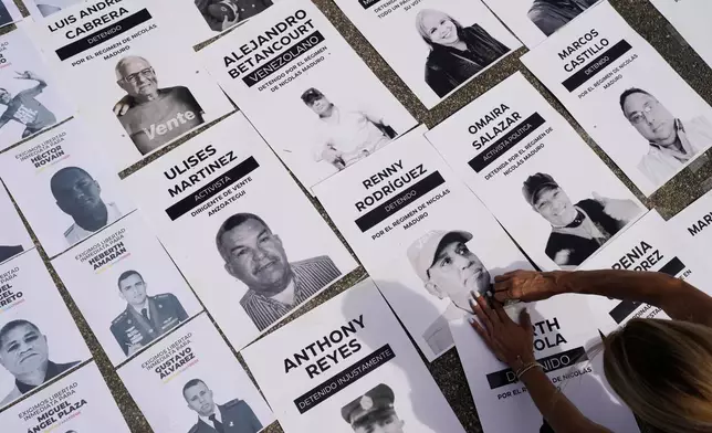 Jacklin Ibarreto, whose father Miguel Ibarreto is detained, lays out photos of political prisoners at the Central University of Venezuela in Caracas, Venezuela, Tuesday, Jan. 13, 2026. (AP Photo/Matias Delacroix)