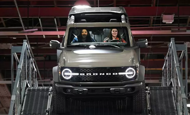 A guest is driven in a Ford Bronco on a test drive course by a Ford employee at the Detroit Auto Show, Wednesday, Jan. 14, 2026, in Detroit. (AP Photo/Jose Juarez)
