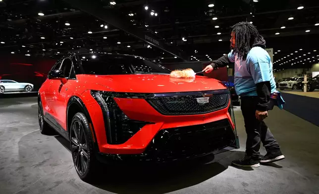 A worker dusts on a 2026 Cadillac Optiq Premium Sport vehicle at the Detroit Auto Show, Wednesday, Jan. 14, 2026, in Detroit. (AP Photo/Jose Juarez)