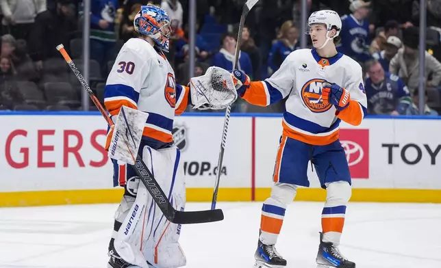 New York Islanders goalie Ilya Sorokin, left, and Matthew Schaefer celebrate after New York defeated the Vancouver Canucks 4-3 during an NHL hockey game in Vancouver, B.C., Monday, Jan. 19, 2026. (Darryl Dyck/The Canadian Press via AP)