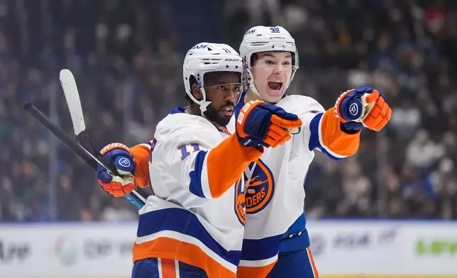 New York Islanders' Anthony Duclair (11) celebrates after his goal with teammate Matthew Schaefer (48) during the first period of an NHL hockey game against the Vancouver Canucks in Vancouver, British Columbia, Monday, Jan. 19, 2026. (Darryl Dyck/The Canadian Press via AP)