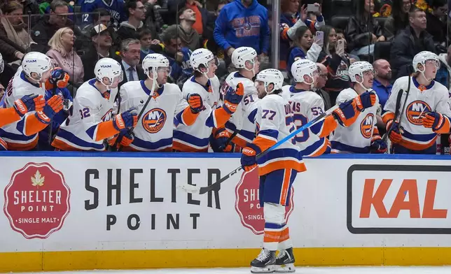 New York Islanders' Tony DeAngelo (77) celebrates his goal against the Vancouver Canucks during the third period of an NHL hockey game, in Vancouver, B.C., Monday, Jan. 19, 2026. (Darryl Dyck/The Canadian Press via AP)