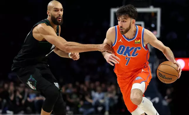 Oklahoma City Thunder center Chet Holmgren, right, works around Minnesota Timberwolves center Rudy Gobert, left, during the first half of an NBA basketball game, Thursday, Jan. 29, 2026, in Minneapolis. (AP Photo/Matt Krohn)