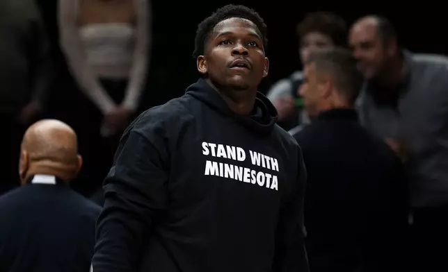 Minnesota Timberwolves guard Anthony Edwards looks on while wearing a shirt that reads "Stand With Minnesota" prior to an NBA basketball game against the Oklahoma City Thunder, Thursday, Jan. 29, 2026, in Minneapolis. (AP Photo/Matt Krohn)