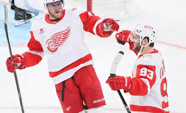 Detroit Red Wings' Alex DeBrincat (93) celebrates with teammate Andrew Copp (18) after scoring against the Montreal Canadiens during the third period of an NHL hockey game in Montreal, Saturday, Jan. 10, 2026. (Graham Hughes/The Canadian Press via AP)
